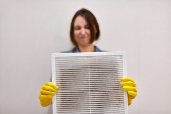 Woman Holding Dirty And Dusty Ventilation Grille, Disgusted